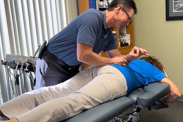 OC Integrative chiropractic adjustment. Chiropractor Dr. Olsen providing hands on myofascial release, adjustment, and chiropractic care to relieve chronic pain, pain relief, hands on treatment, chiropractic treatment.